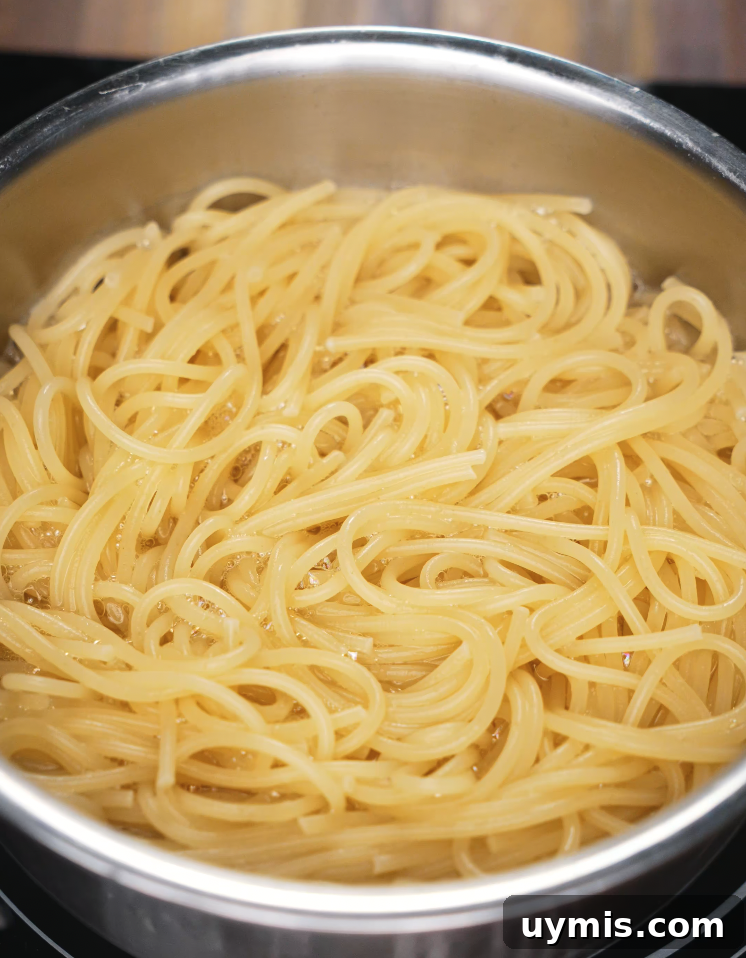 Spicy Chili Oil Pasta with Caramelized Onions 4 Spaghetti boiling in a stainless steel pot, cooked until al dente for the chili oil pasta.