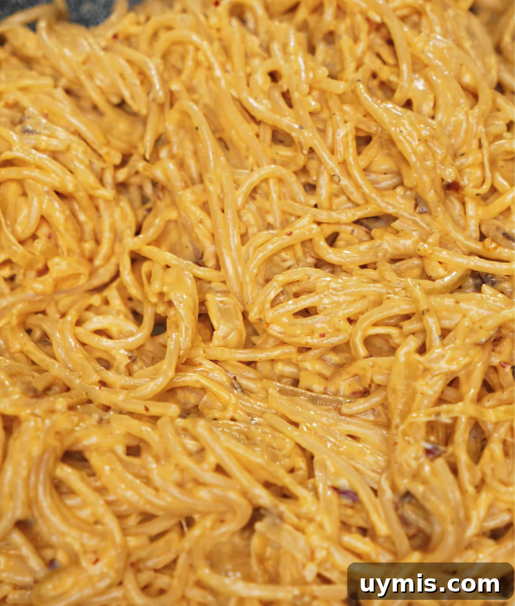Spicy Chili Oil Pasta with Caramelized Onions 7 Spaghetti fully mixed into the rich, creamy chili oil sauce, coating each noodle evenly.