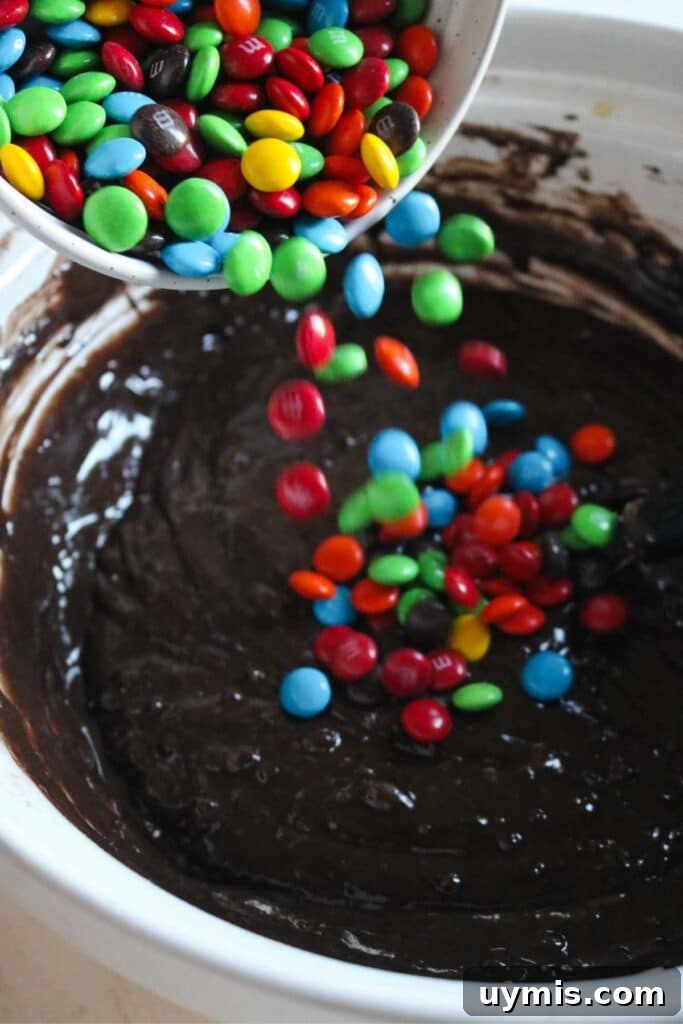 Thick and Chewy M&M Brownies Recipe 17 m&m brownie batter spread into a prepared baking pan.
