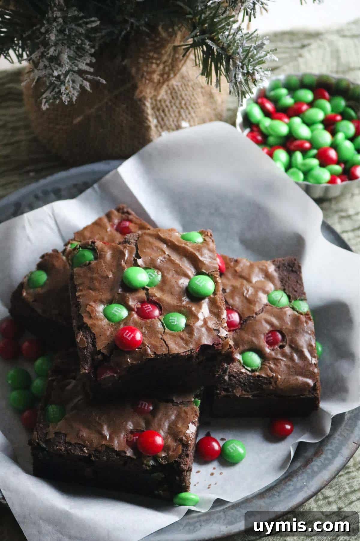 Thick and Chewy M&M Brownies Recipe 5 antique pie plate with christmas themed M&M brownies with red and green M&M candies.