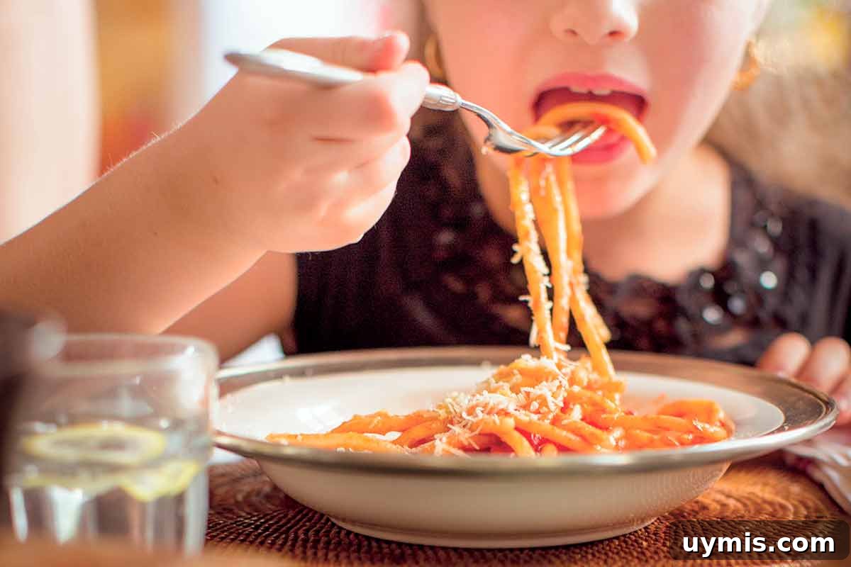 Sugo di Pomodoro Italian Tomato Sauce Recipe 4 A child eating a bowl of cooked pasta with red sauce.