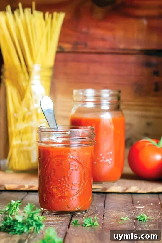 Sugo di Pomodoro Italian Tomato Sauce Recipe 7 Spicy marinara sauce in a small mason jar with tomatoes and parsley in the background.