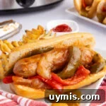 Sausage on a bun served on a white plate.