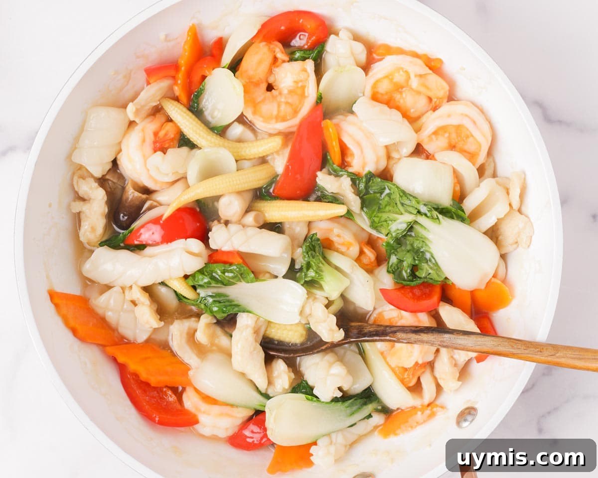 Vietnamese Crispy Noodle Stir Fry Mi Xao Gion 23 Mixing the proteins and vegetables in the sauce.