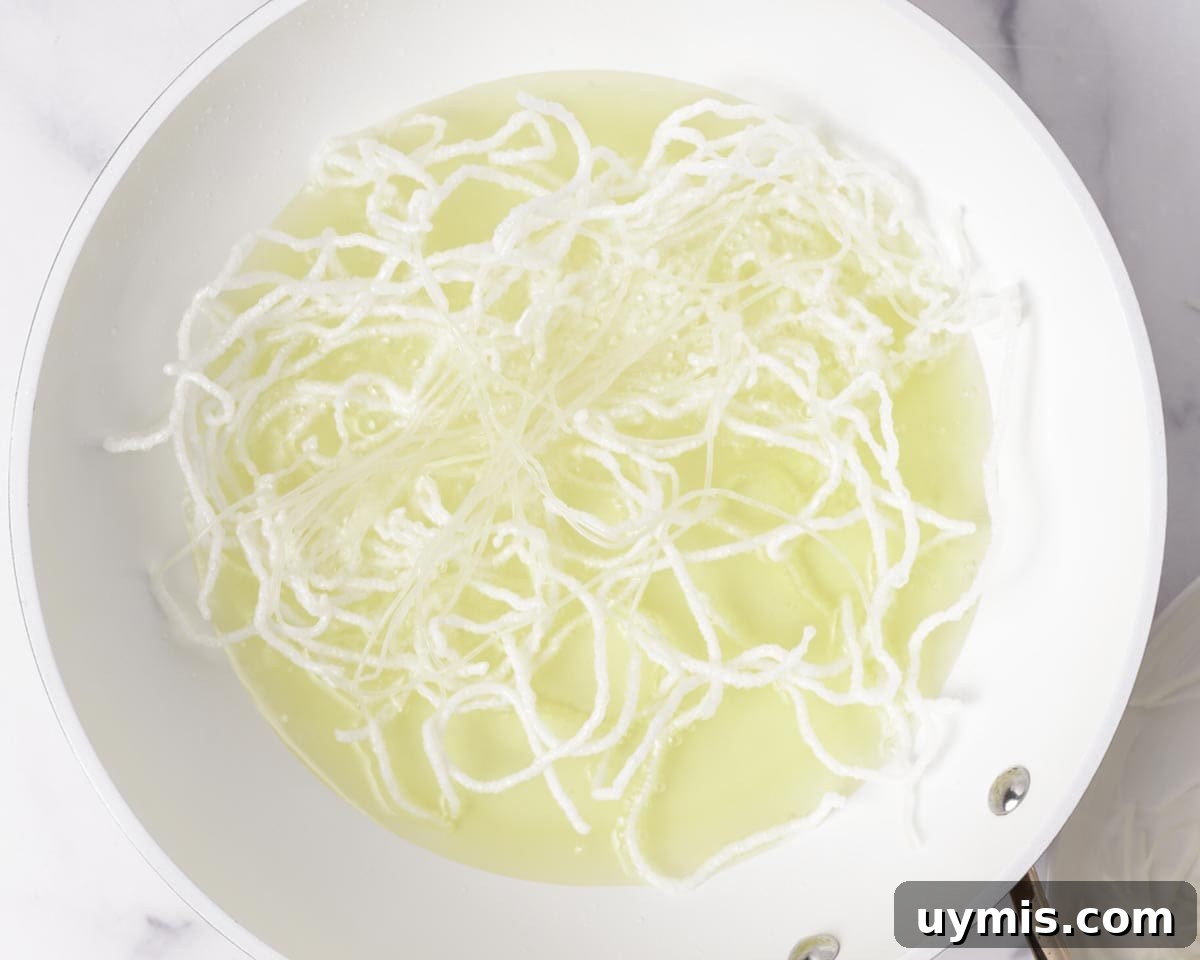 Vietnamese Crispy Noodle Stir Fry Mi Xao Gion 31 Frying rice vermicelli noodles in a pan of oil.