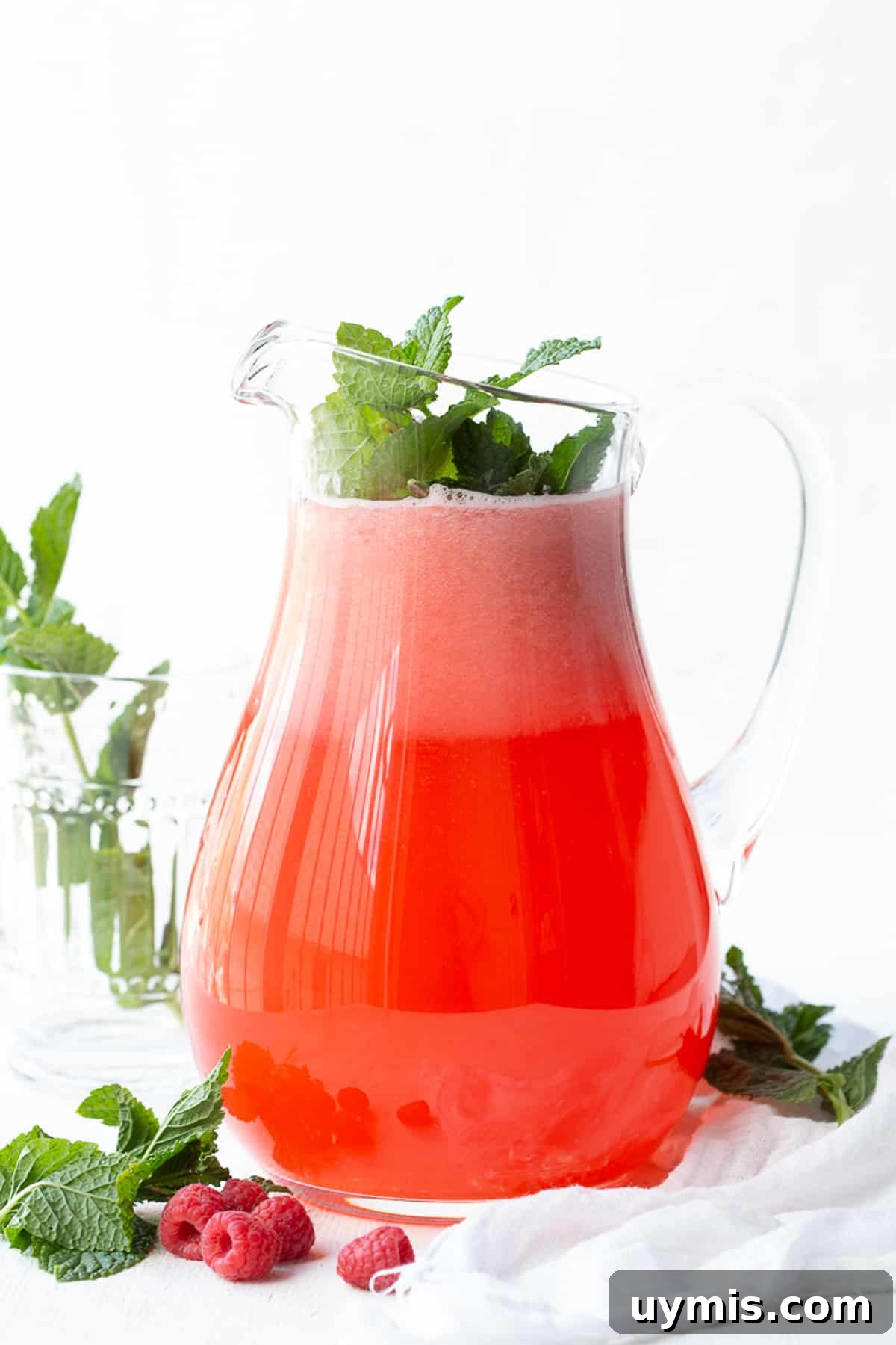 Two Ingredient Raspberry Lemonade Recipe 6 large pitcher of raspberry lemonade, garnished with mint.
