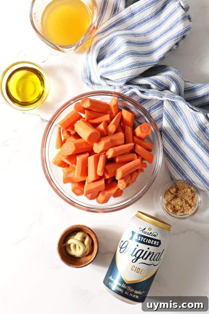 Carrots in a bowl and other ingredients to make cider glazed carrots on marble with a blue striped towel