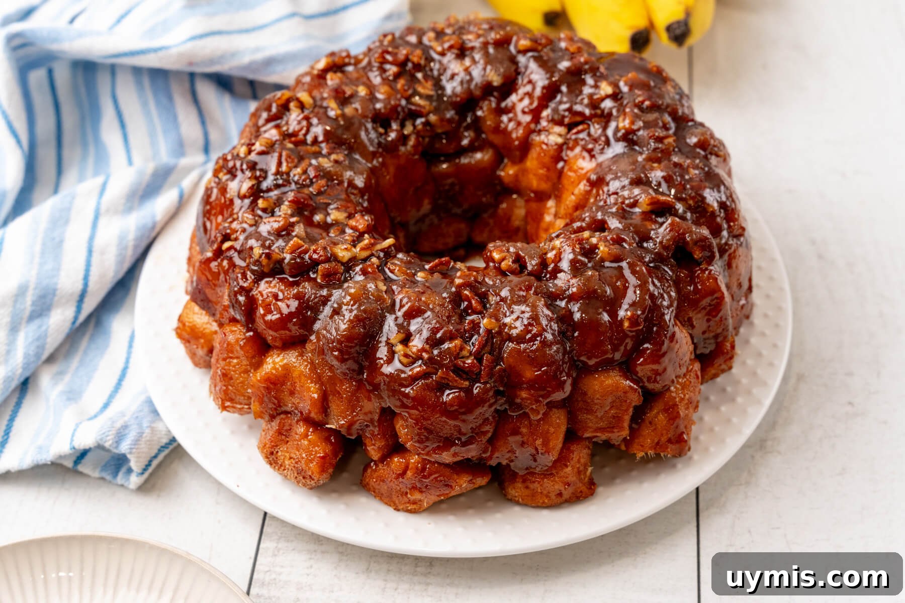 Warm Bananas Foster Monkey Bread with Rum-Caramel Glaze 2 Bananas Foster Monkey Bread sits on a white plate.