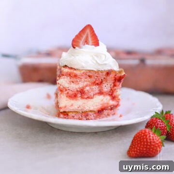 piece of strawberry earthquake cake topped with whipped cream and a strawberry.