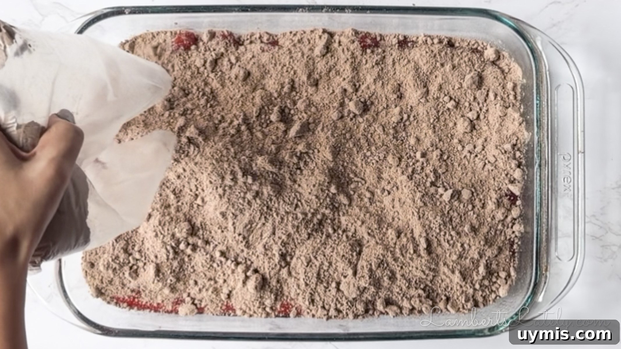 Chocolate Cherry Dump Cake Recipe 7 pouring dry chocolate brownie mix over cherry pie filling.