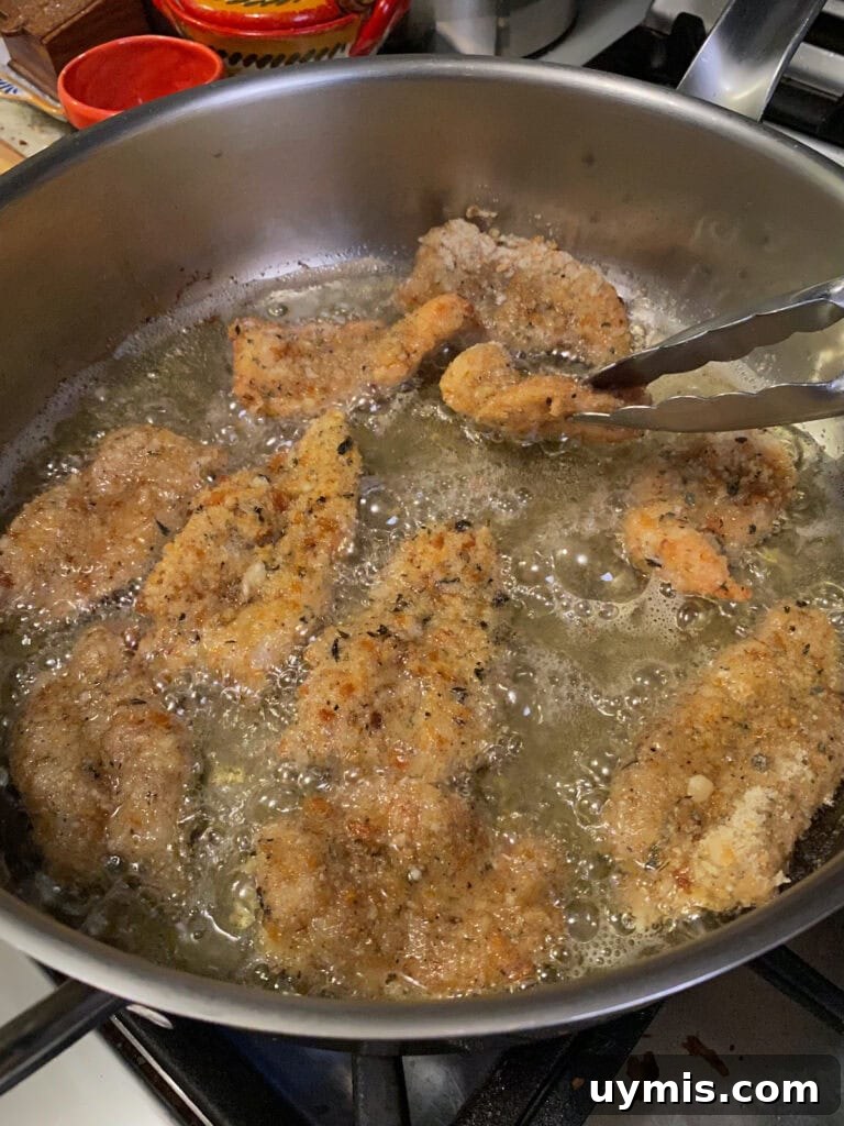 Italian Pan Fried Butterflied Shrimp Recipe 15 Turning a piece of shrimp frying in large pan over to brown the other side.