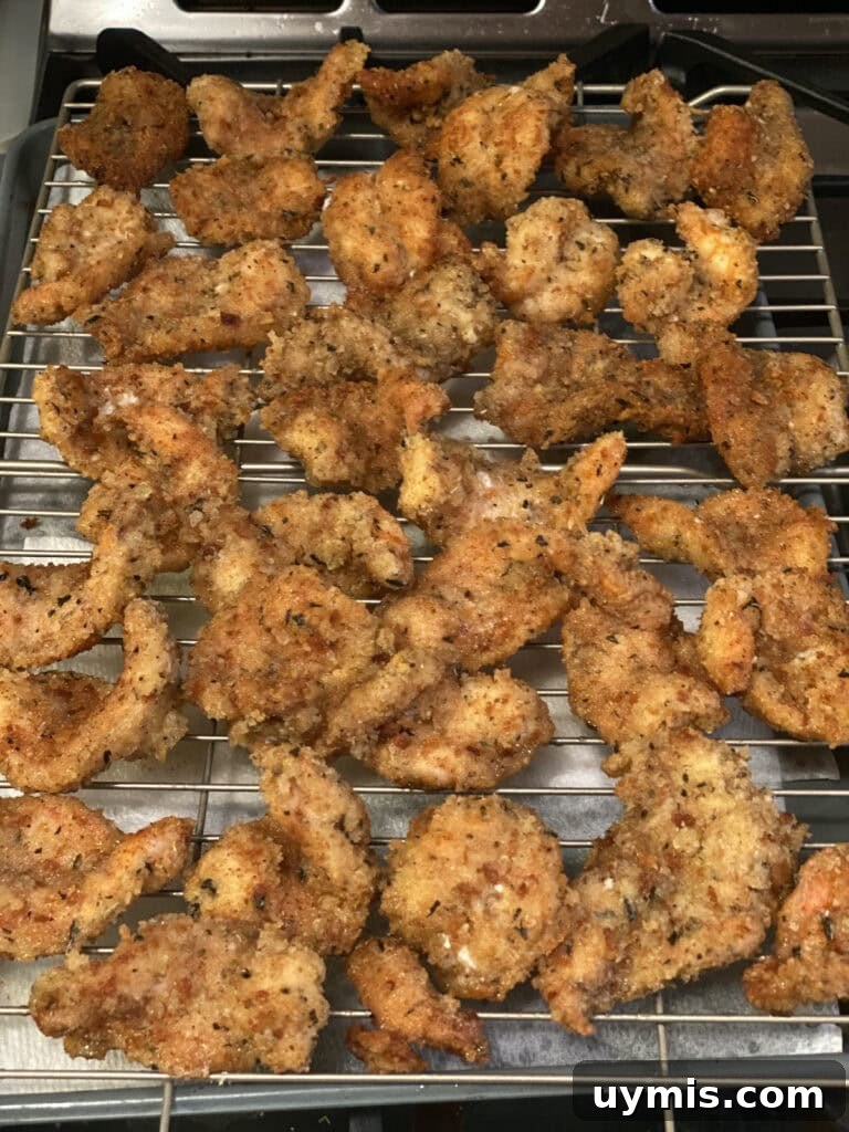 Italian Pan Fried Butterflied Shrimp Recipe 3 Finished pan fried butterflied shrimp on a wire rack over a sheet pan.