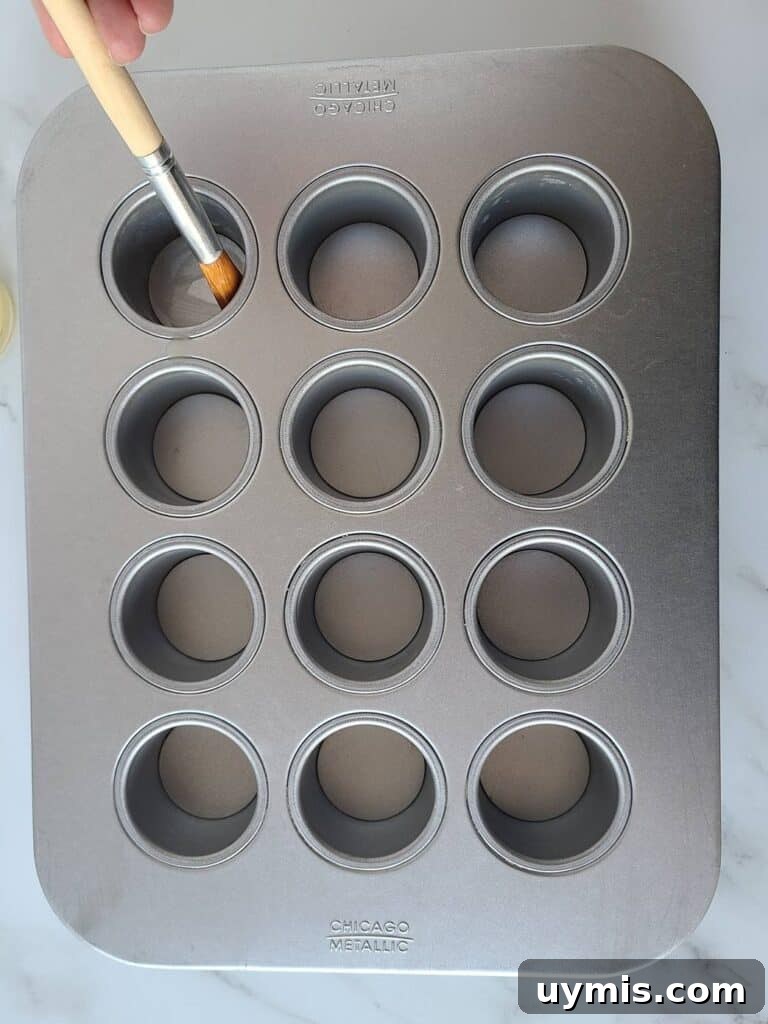 Mini Crème Brûlée Cheesecake Bites Recipe 9 Buttering mini cheesecake pan.