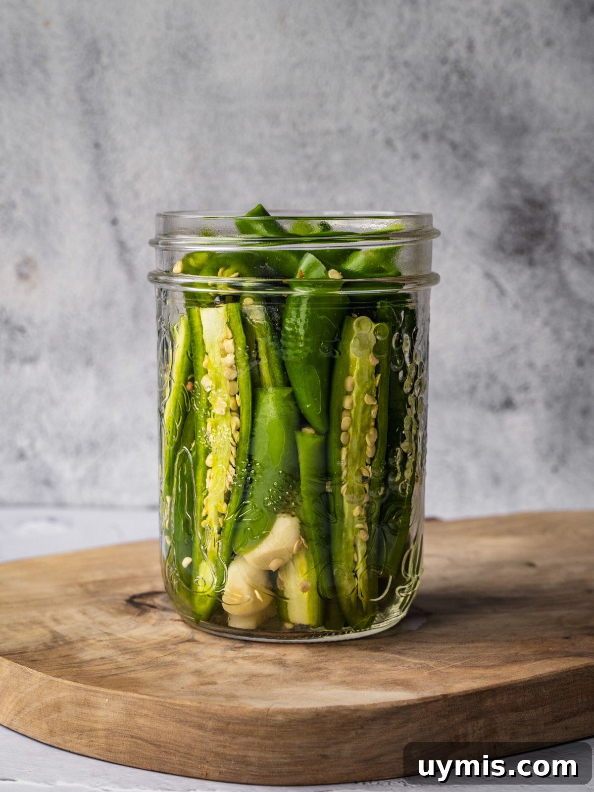 How to Make Pickled Serrano Peppers 5 A jar packed with sliced serrano peppers and garlic.