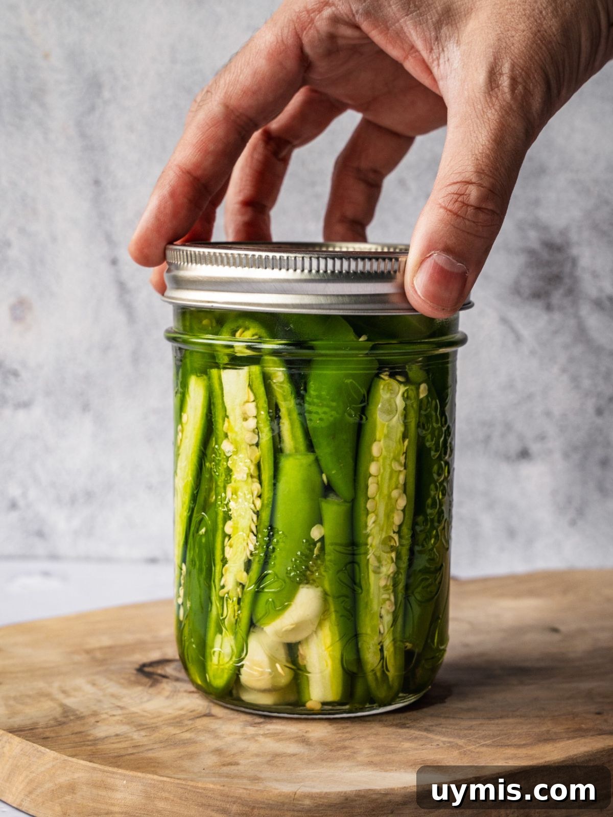 How to Make Pickled Serrano Peppers 7 Adding a lid to a jar of pickled peppers.