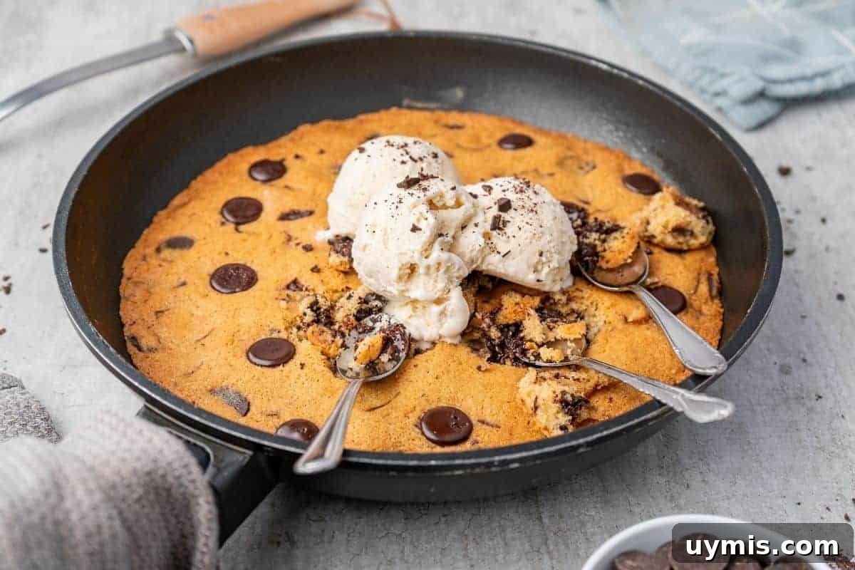 27 Chocolate Desserts You Can't Keep at Home 11 Overhead shot of a warm chocolate chip skillet cookie in a black skillet, topped with scoops of vanilla ice cream and three spoons.