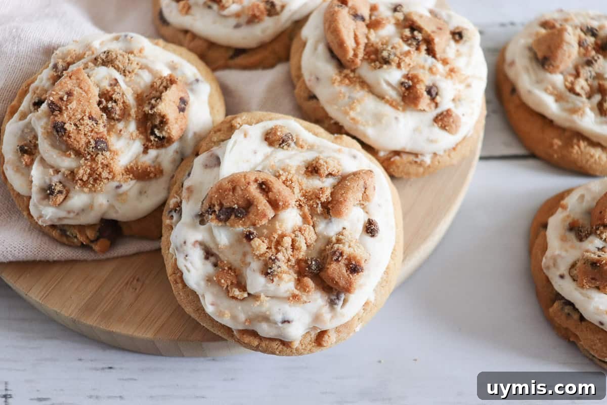 27 Chocolate Desserts You Can't Keep at Home 19 Frosted chocolate chip cookie cookies on a wooden cutting board.