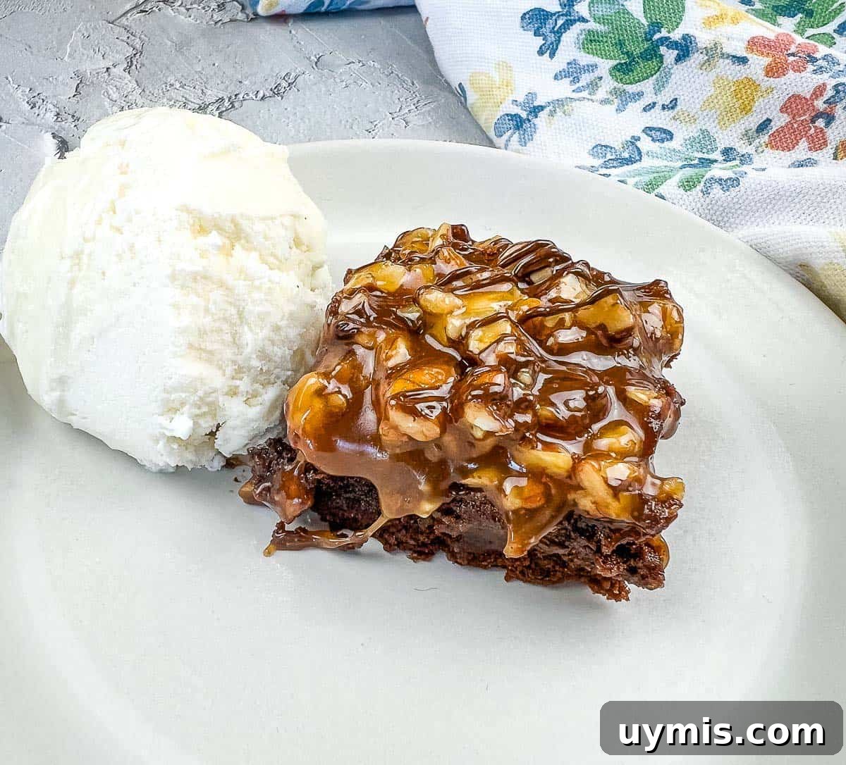27 Chocolate Desserts You Can't Keep at Home 23 A piece of Turtle Brownie with ice cream on a plate.