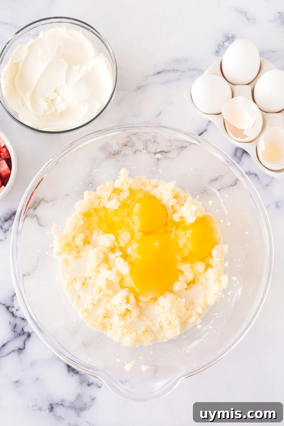 Moist Strawberry Sheet Cake with Cream Cheese Frosting 4 Eggs and milk added to creamed butter and sugar in glass mixing bowl.
