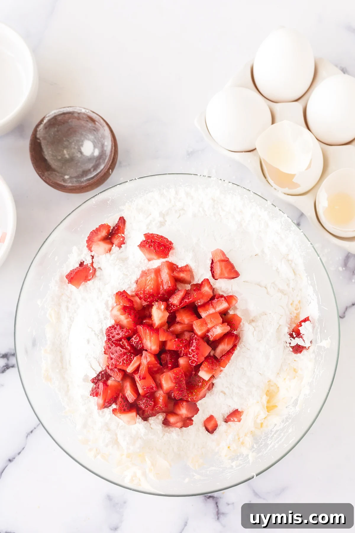 Moist Strawberry Sheet Cake with Cream Cheese Frosting 7 Diced strawberries added to cream cheese in bowl.