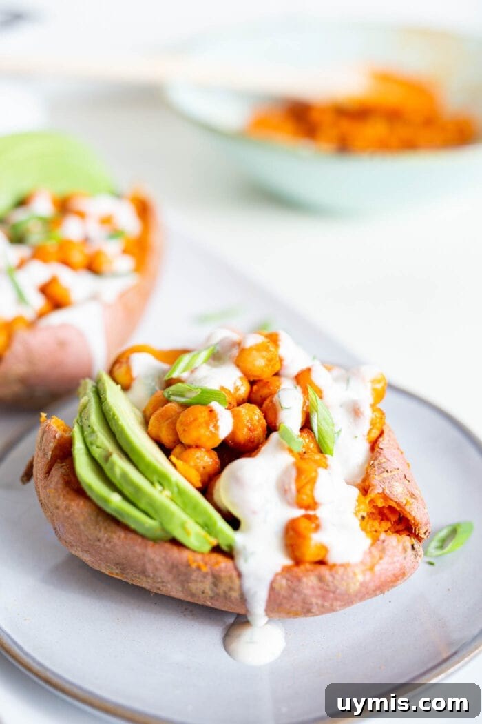 Spicy Buffalo Chickpea Stuffed Sweet Potatoes 4 Sweet potato stuffed with buffalo chickpeas and avocado, topped with white sauce.