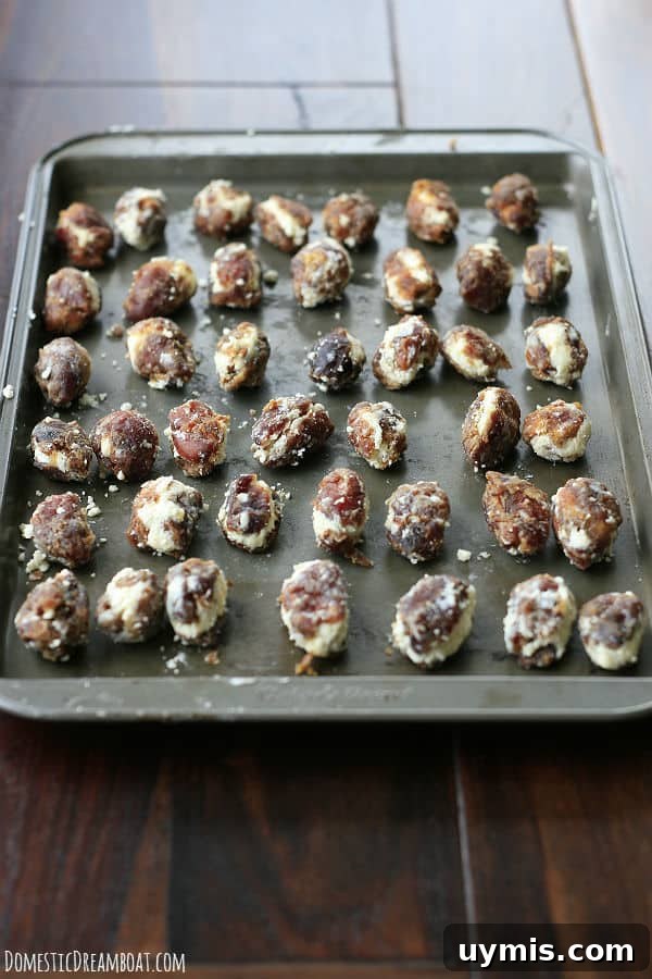 Bacon Wrapped Dates Stuffed with Blue Cheese and Almonds 3 Stuffed dates on a baking sheet before being wrapped with bacon.