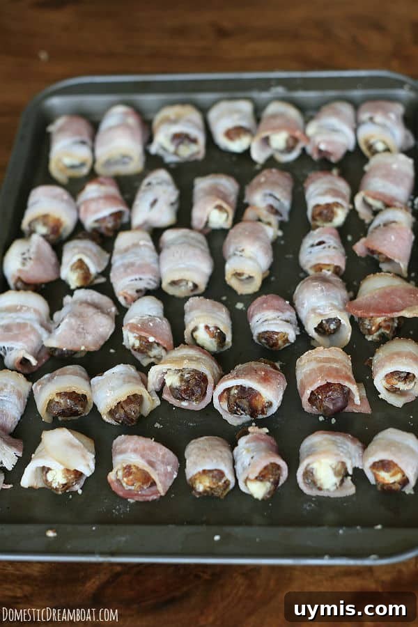 Bacon Wrapped Dates Stuffed with Blue Cheese and Almonds 4 Bacon-Wrapped Stuffed Dates on a baking sheet before baking.