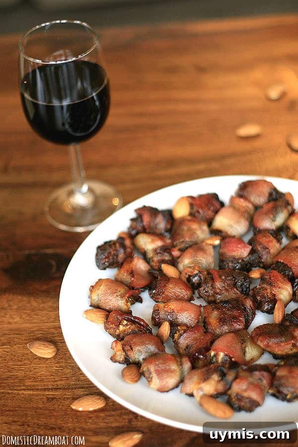 Bacon Wrapped Dates Stuffed with Blue Cheese and Almonds 5 Bacon-Wrapped Stuffed Dates on a white plate with a glass of wine in the background.