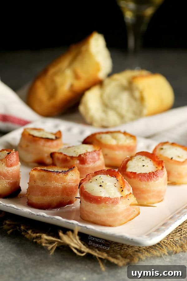 Bacon Wrapped Dates Stuffed with Blue Cheese and Almonds 6 Bacon wrapped scallops on a plate