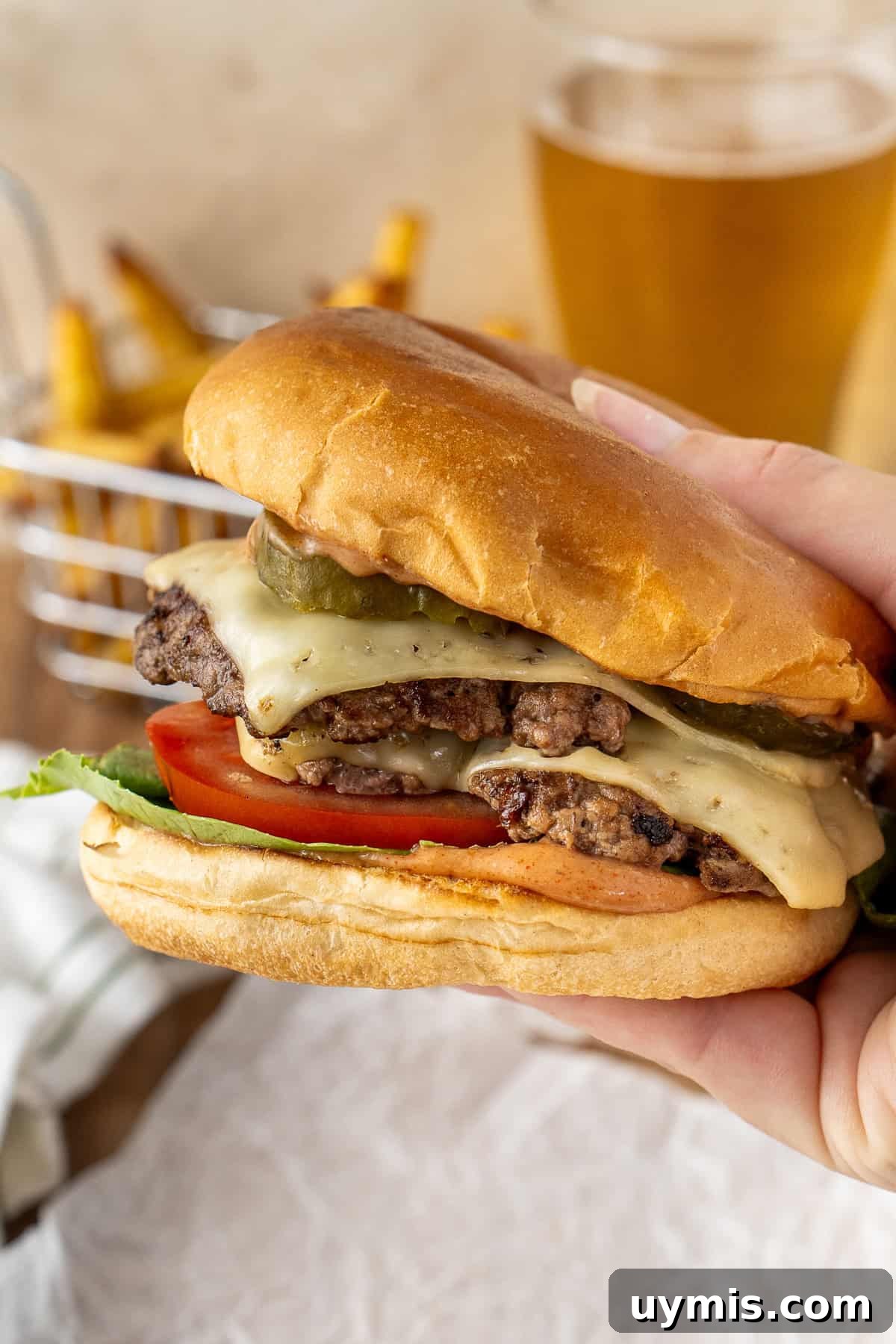 Smash Burger Recipe with Crispy Edges 12 A hand picking up a smash burger.