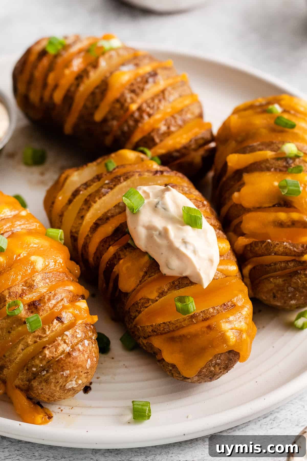 Cheesy hasselback potatoes on a plate.