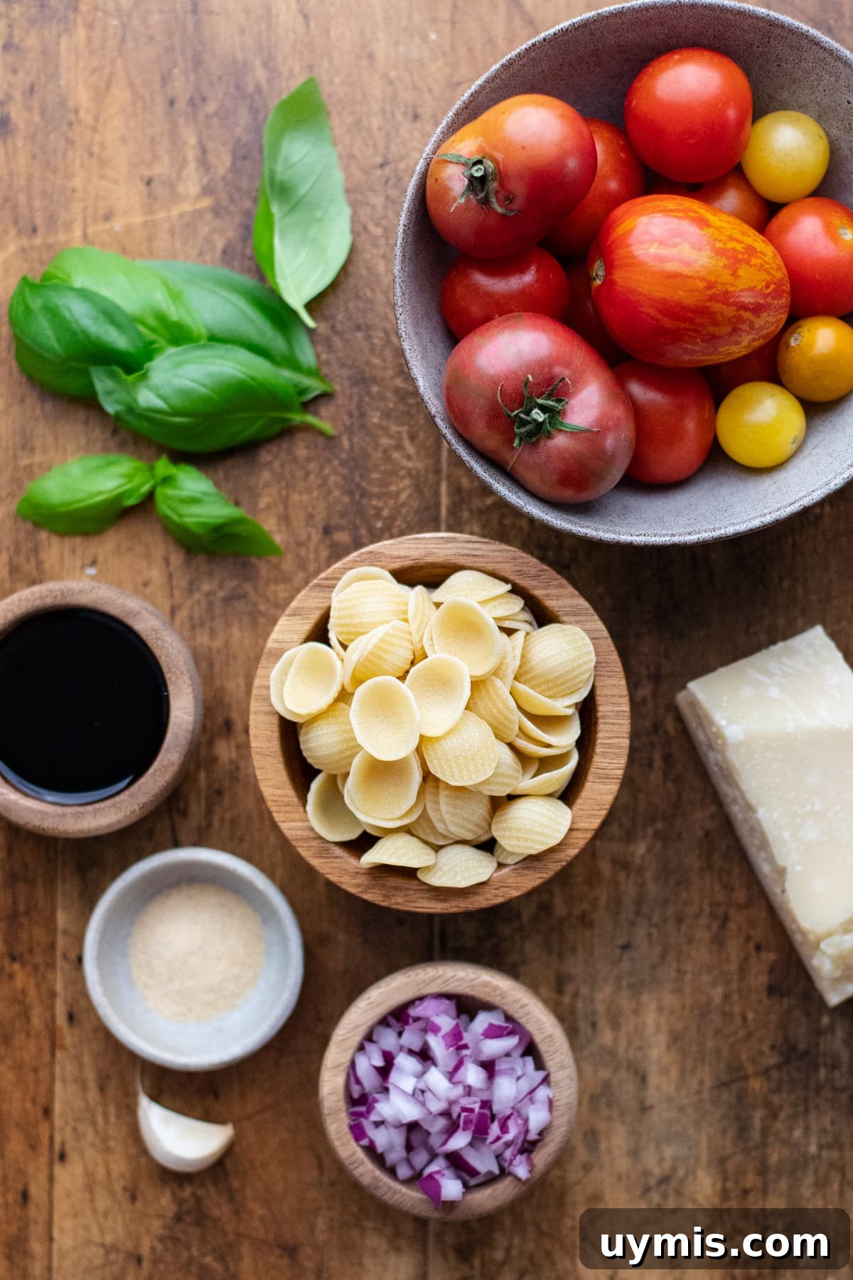 Bruschetta Pasta with Roasted Tomatoes and Basil 3 Ingredients for bruschetta pasta arranged on a wooden background.