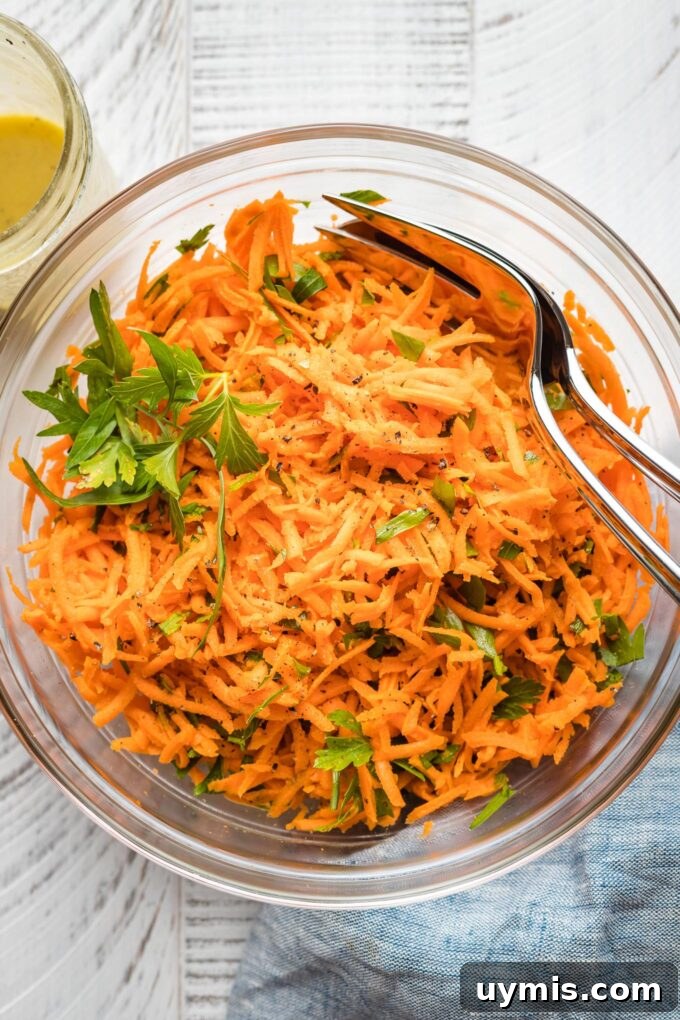 Clear glass bowl holding a French carrot salad.