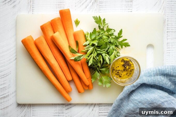 Peeled carrots, flat-leaf parsley, and a jar of salad dressing on a white cutting board.