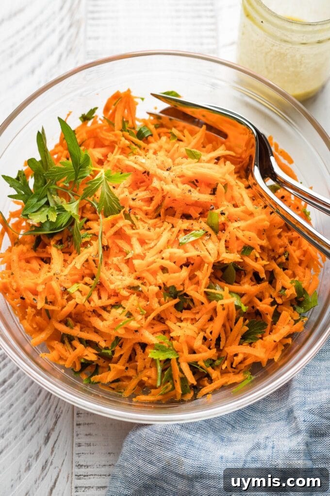 Clear glass bowl holding a French carrot salad.