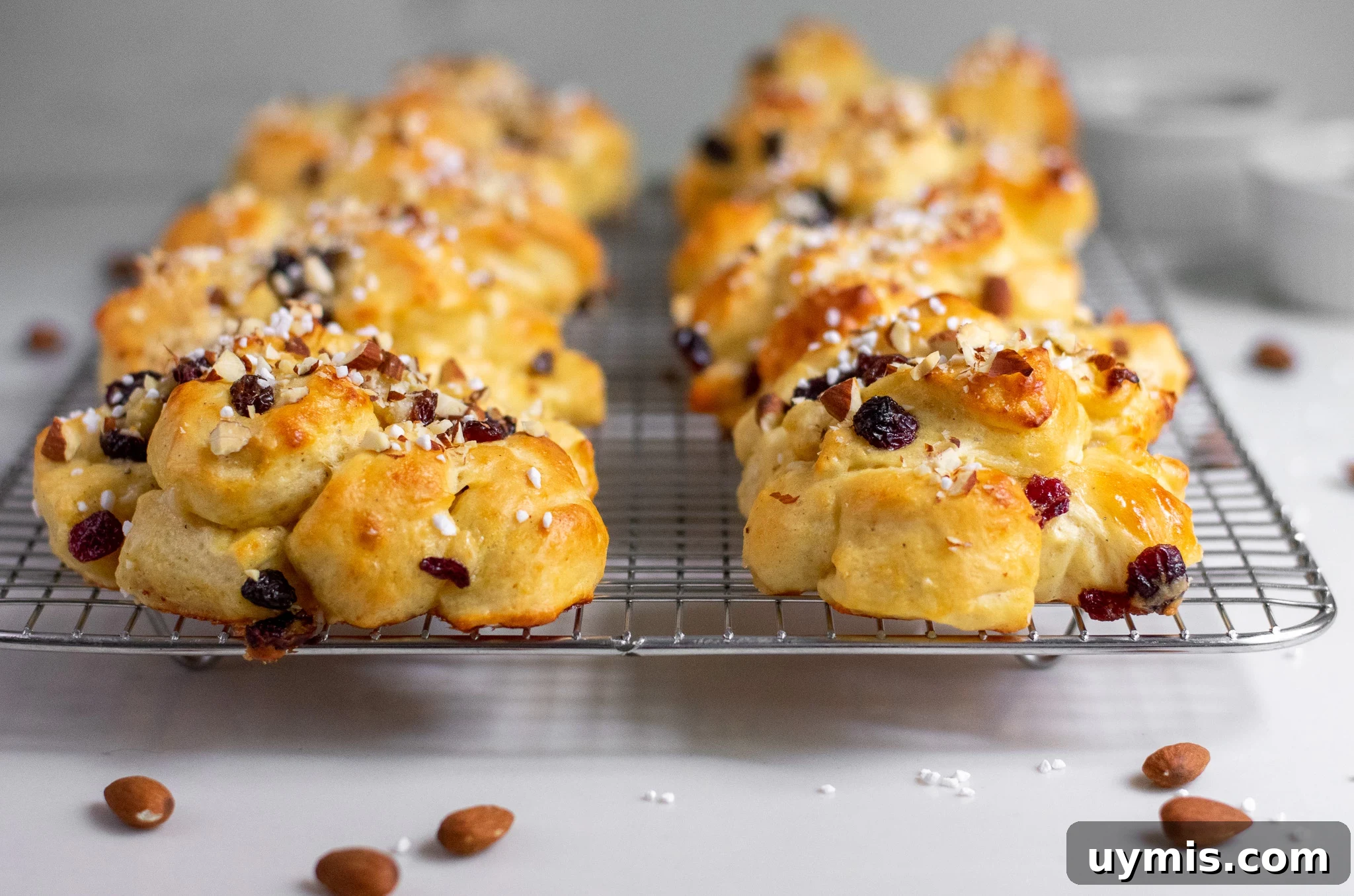Cardamom flavored rolls with marzipan and dried fruit topped with almonds and pearl sugar.