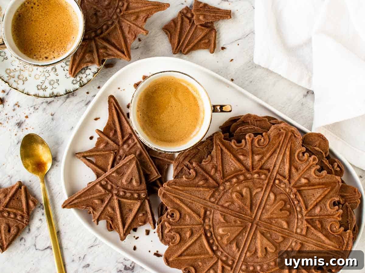 Chocolate Pizzelle Recipe 6 chocolate wafer cookies on white plate with two espresso coffees in cup.