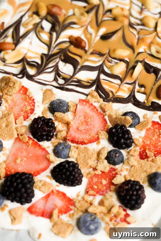 Viral High Protein Frozen Cottage Cheese Bark 13 high protein frozen dessert topped with fruit, graham cracker, peanut butter, peanuts, and chocolate