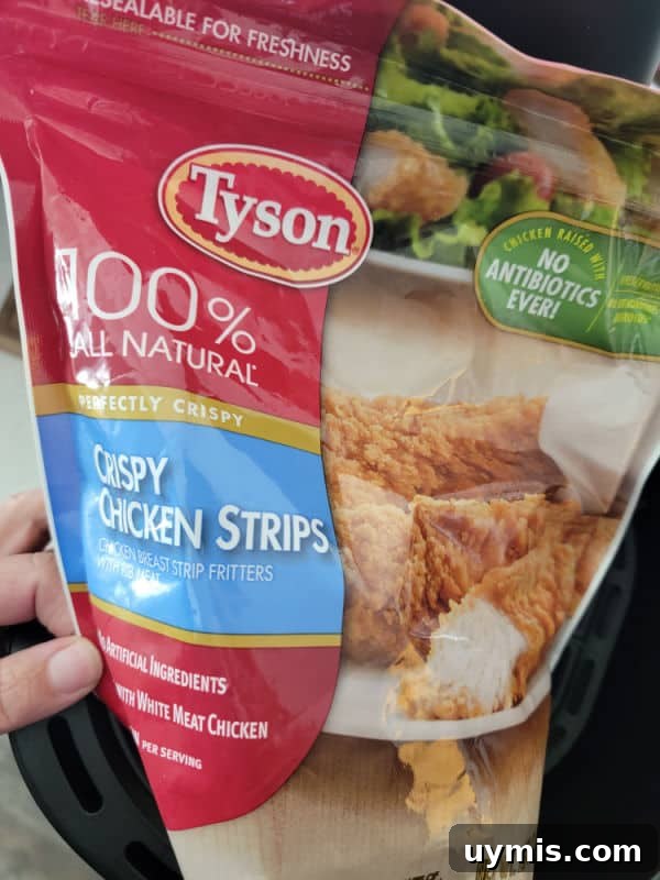 Air Fryer Frozen Chicken Tenders in 12 Minutes 3 Tyson Crispy Chicken Strips bag held over an air fryer