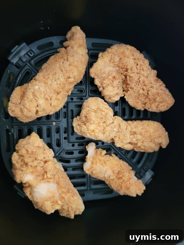 Air Fryer Frozen Chicken Tenders in 12 Minutes 4 Chicken strips in an air fryer basket