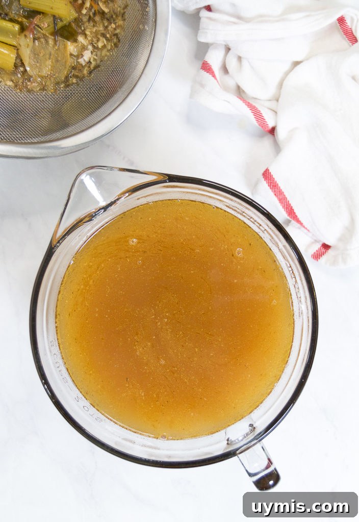 How to Make Instant Pot Turkey Stock 2 A pitcher of turkey stock next to a sieve of bones