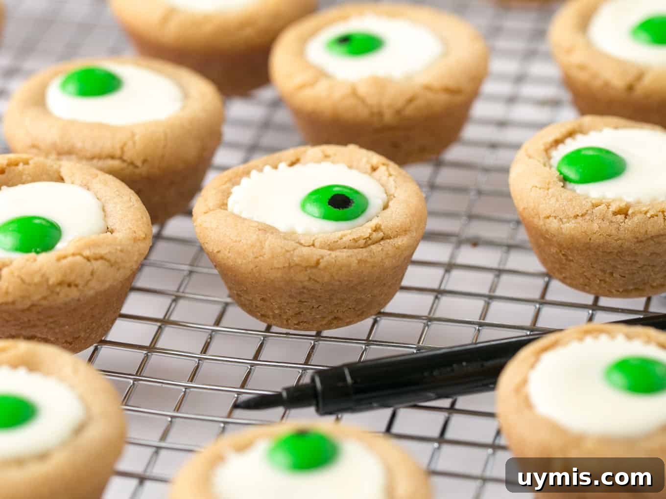 Halloween Eyeball Cookies with Peanut Butter Cups 13 Mini white peanut butter cup cookies with green M&M in center to look like Halloween eyeball.