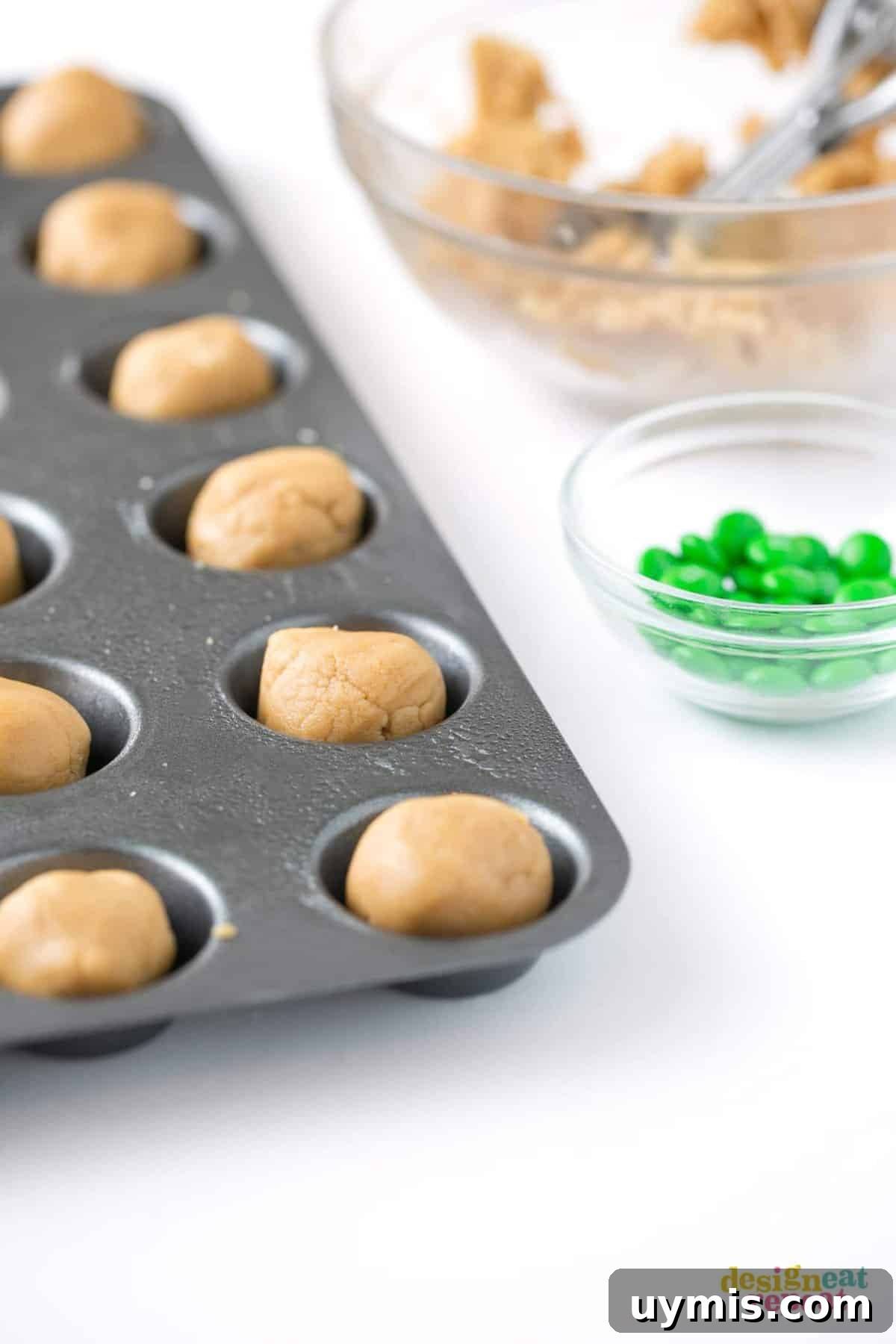 Halloween Eyeball Cookies with Peanut Butter Cups 9 Mini muffin tin of peanut butter cookie dough balls before baking.