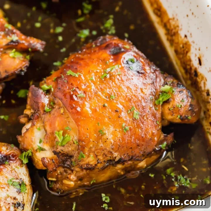 A close up image of a roasted balsamic chicken thigh in the pan.
