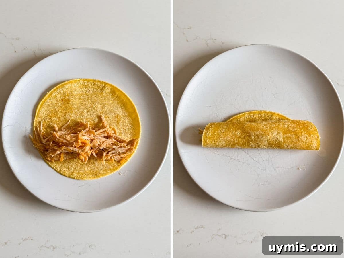 Chicken filling in the warmed corn tortilla and then the tortilla rolled tightly.