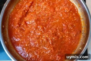 Adding the crushed tomatoes