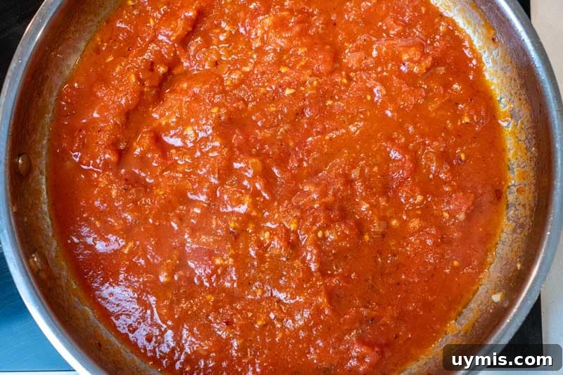Adding the crushed tomatoes