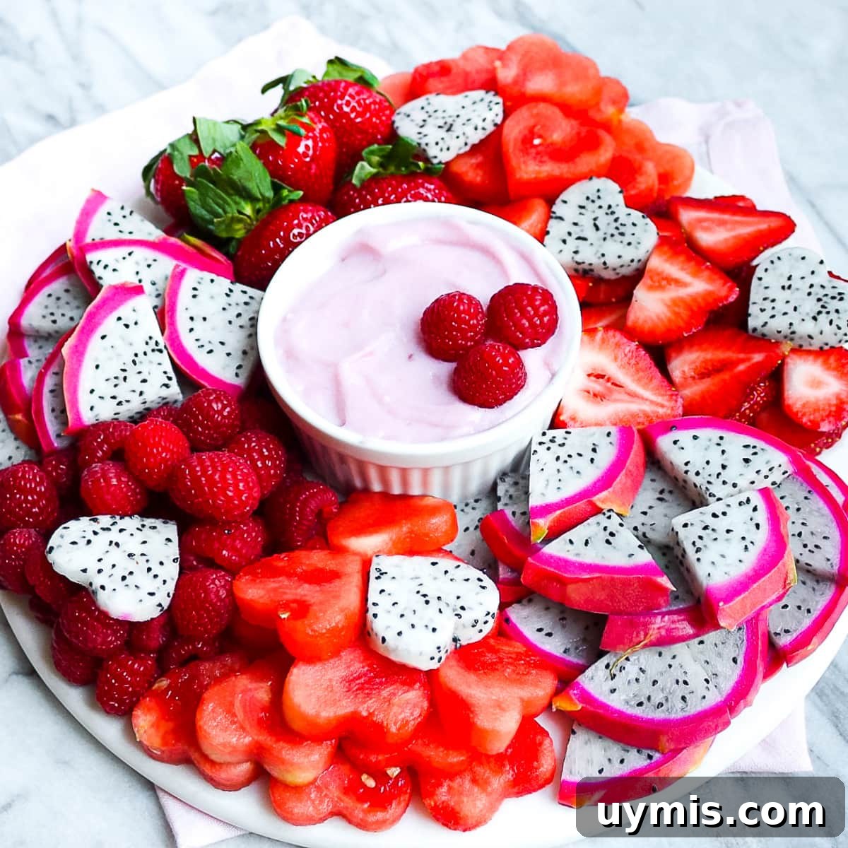 Creamy Vegan Fruit Dip Recipe for Fresh Fruit Platters 3 A fruit platter with fresh berries, melon, and dragon fruit with a homemade fruit dip in the center.