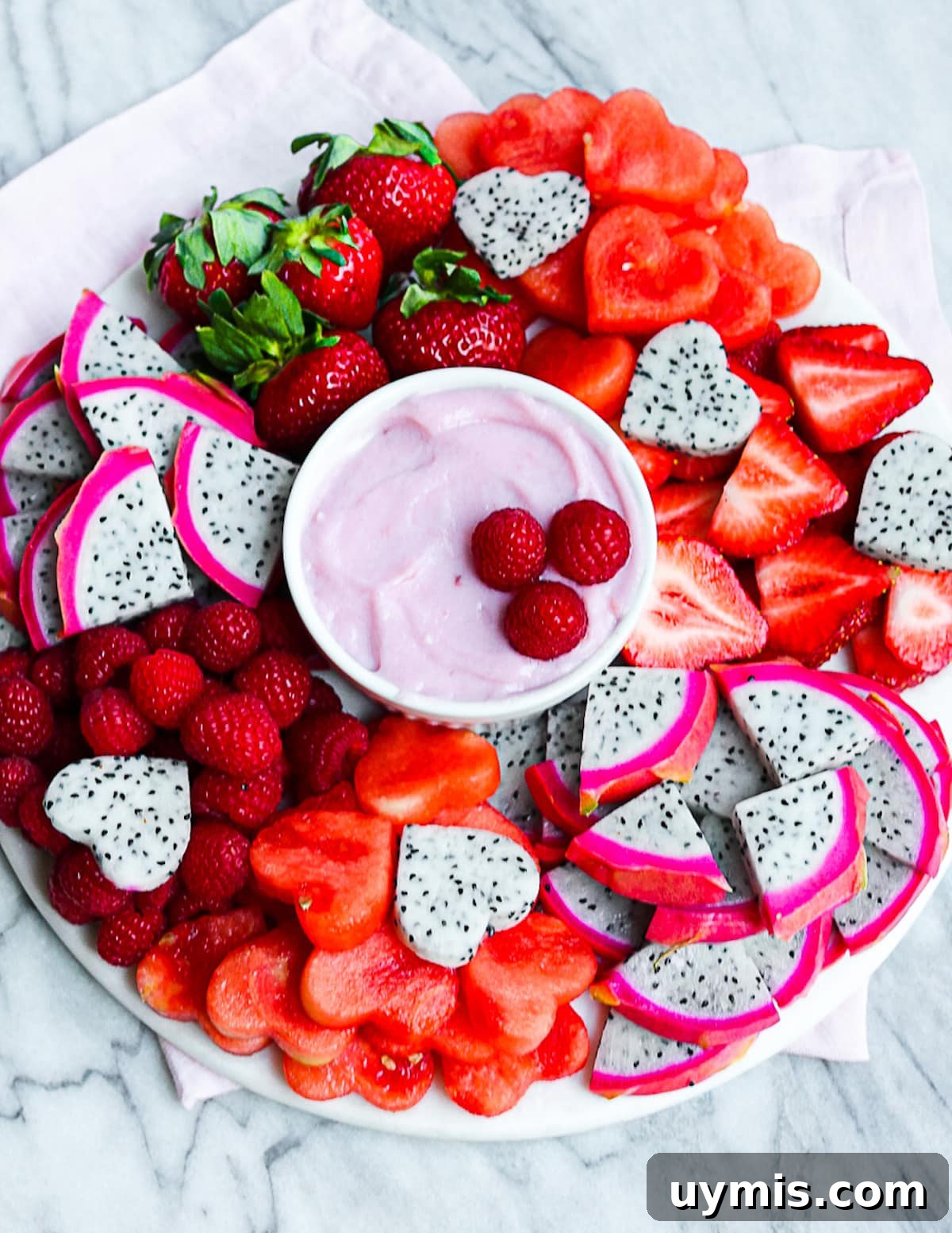Creamy Vegan Fruit Dip Recipe for Fresh Fruit Platters 4 A platter filled with fresh red fruits and with a bowl of dip in the middle