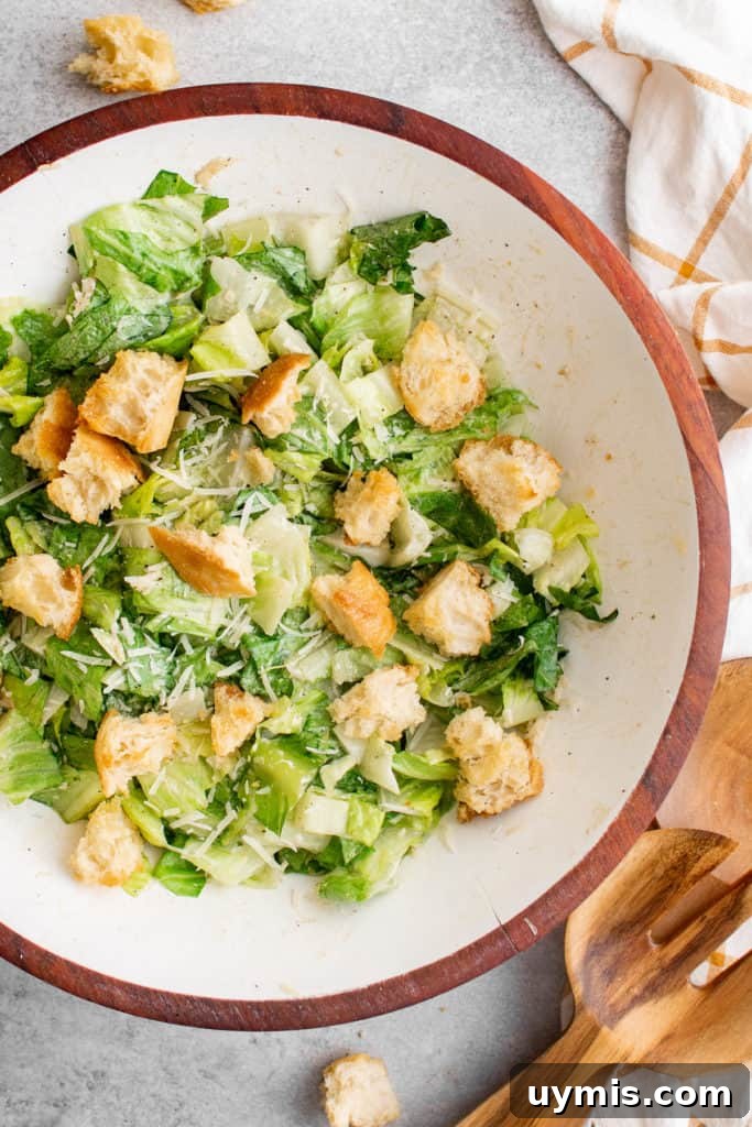Homemade Caesar Salad Recipe with Classic Parmesan Dressing 2 Top down view of a salad and croutons in a bowl.